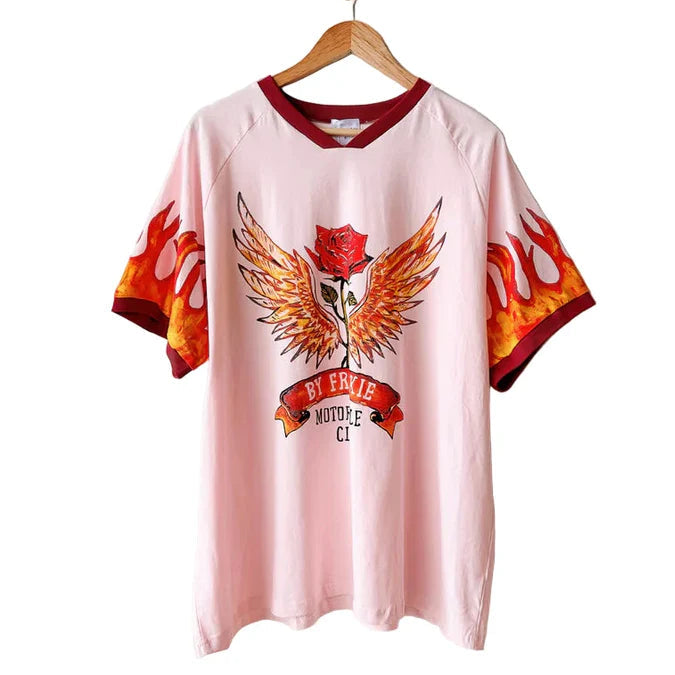 Pink t-shirt with a graphic design on a hanger against a white background